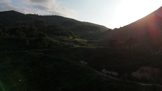 lever du soleil, maison et colines en contrejour 