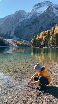 Enjoying the serene beauty of Lago di Bries in Italy while capturing nature's reflections on a clear autumn day