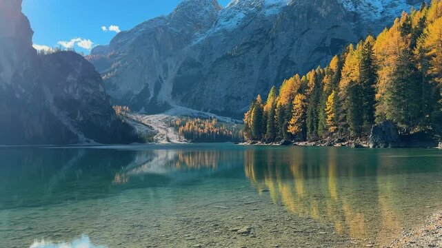 Lago di Bries in Italy showcases stunning autumn colors and serene mountain reflections at dawn