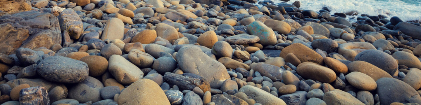Fototapeta Deserted rocky pebble beach. Abstract nature pebbles background. Pebbles texture. Stone beach. Horizontal banner