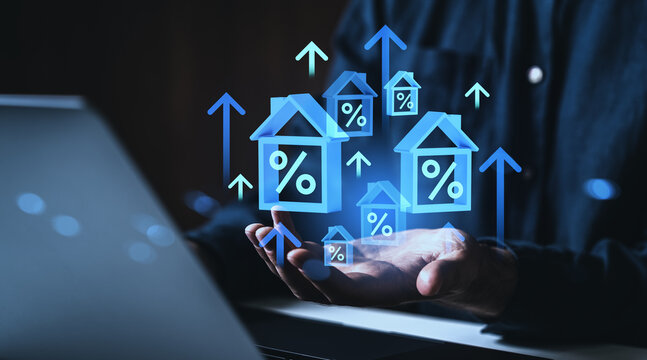 Rising mortgage rates and real estate market concept with digital house icons and percentage signs hovering over a hand in futuristic style on dark background.
