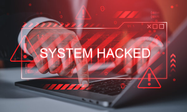 System hacked alert with red warning signs overlay on businessman using laptop, symbolizing online virus attack and cybersecurity breach concept.