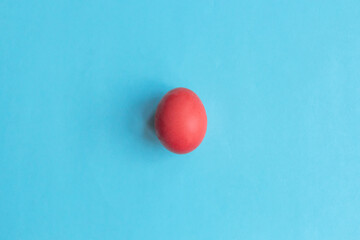 Trend colored pink chicken egg on a blue pastel minimalistic background