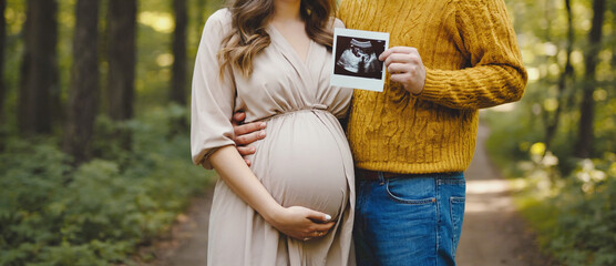 Expecting Parenthood's Embrace: An intimate capture of anticipation and love, a pregnant woman tenderly cradles her baby bump, while her partner displays an ultrasound scan in a verdant.