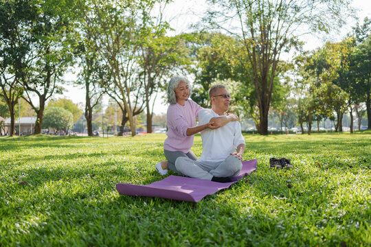Happy senior asian woman and friend enjoy healthy lifestyle, doing yoga exercise and stretching together outdoor in sunny park