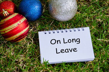Top view of On Long Leave text on white notepad with Christmas decoration background.