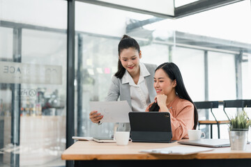 Professional asian businesswoman in focused office meeting, showing positive collaboration and teamwork while discussing document and report