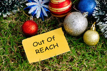 Top view of Out of REACH text with Christmas decoration background.