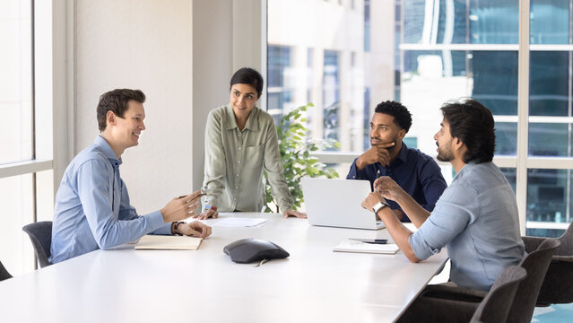 Diverse group of multicultural businesspeople gather for workshop at boardroom
