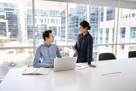 Millennial female giving feedback on work of young male colleague