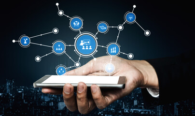A smartphone held in a hand showcases a complex digital network of social media icons and connections. Perfect for illustrating technology and digital communication concepts. Tessel
