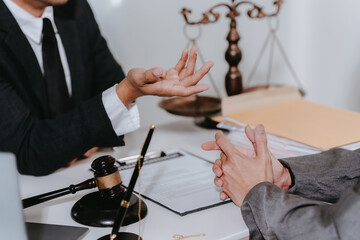 Lawyer, man giving advice to client at table with scales and gavel. Lawyer handing document and pen...