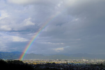 岐阜県池田町の雨上がりの虹と光の刺す街並みと山