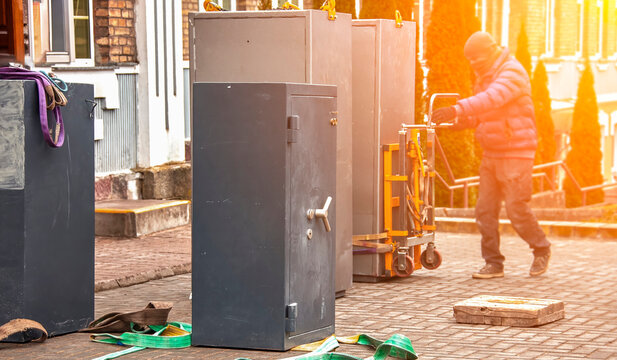 Safe removal in an urban area by a worker using a dolly in afternoon sunlight during a relocation project