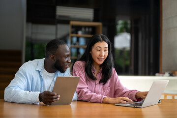 Remote work and digital business. Diverse couple collaborating online, managing projects with laptop