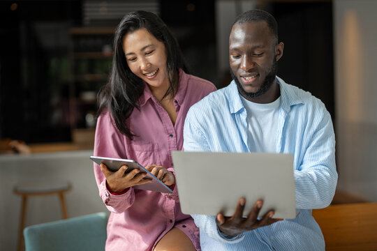 Multiethnic freelancer couple enjoy the environment of tropical climate, working on laptop together