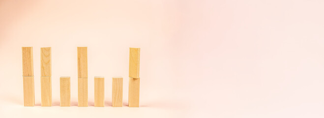 pastel growth chart with wooden blocks on soft peach background, rising bar arrangement evokes business analytics and success metaphor, clean minimal composition for presentations and social