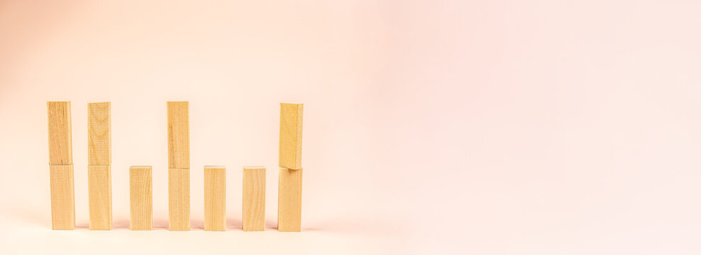 pastel growth chart with wooden blocks on soft peach background, rising bar arrangement evokes business analytics and success metaphor, clean minimal composition for presentations and social