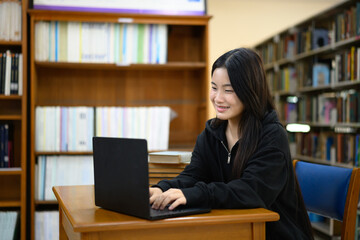 Teenage woman education or internet encyclopedia concept. Open laptop in library