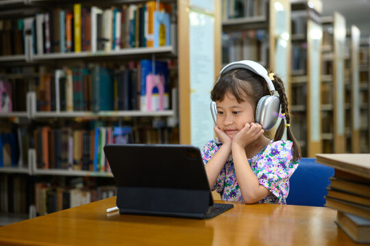 Photo set Asian little girl learning on tablet in library, smiling happiness