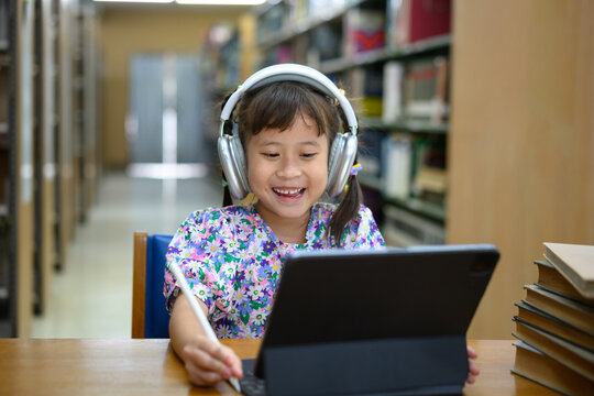Photo set Asian little girl learning on tablet in library, smiling happiness