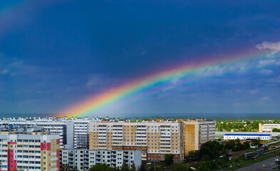 Fantastic beautiful rainbow over city buildings after rain