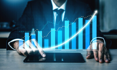 A business professional examines growth data on a tablet, illustrating financial trends with various charts and graphs in a sleek office setting. Impute