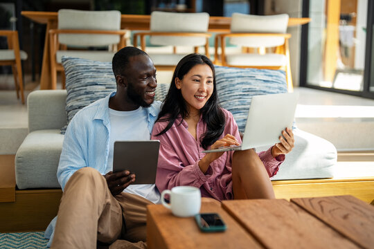 Multiethnic freelancer couple enjoy the environment of tropical climate, working on laptop together