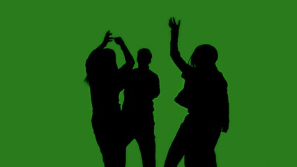 Black isolated silhouettes of people dancing cheerfully on a green chroma key background. Minimalist contrast and modern visual composition, mockup.