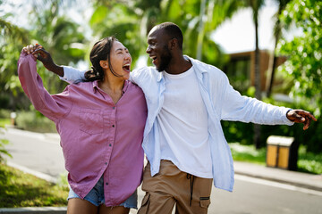 Diverse couple enjoying vacation, embracing travel, relaxation, and happiness in tropical paradise