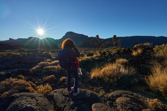 Woman photographer shooting Roques de Garcia with Mount Guajara in the background