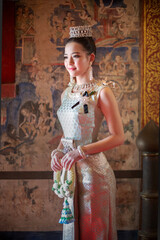 Beautiful young Asian woman in traditional Thai Dusit dress in an old temple in Chiang Mai, Thailand.