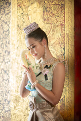 Beautiful young Asian woman in traditional Thai Dusit dress in an old temple in Chiang Mai, Thailand.