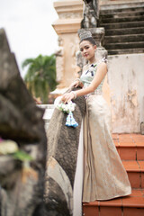 Beautiful young Asian woman in traditional Thai Dusit dress in an old temple in Chiang Mai, Thailand.