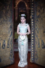 Beautiful young Asian woman in traditional Thai Dusit dress in an old temple in Chiang Mai, Thailand.