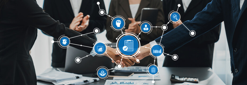 A dynamic visual of business professionals engaging in collaboration highlighted by a handshake, surrounded by icons representing technology and communication in a modern office setting. Amity