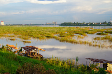 Rustic river huts and flooded grassland along the Mekong River, Vientiane, Laos