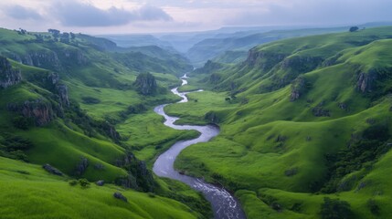 Fototapeta premium Serene valley landscape with winding river. Lush green hills and cliffs meet a flowing river