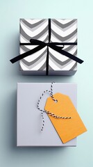 A top-down view of two gift boxes against a light blue background, one wrapped in a chevron pattern with a black ribbon, the other a plain gray box with an oran