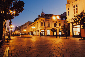 Fototapeta premium Historic city street with warm lights at twilight 