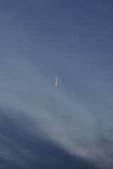 Jet airplane leaving contrail in twilight sky
