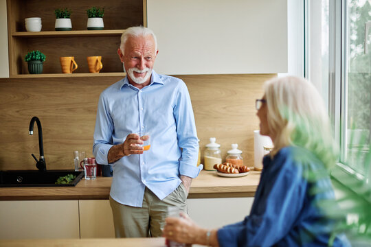Portrait of a happy active senior couple dating and flirting in a restaurant, or at home in kitchen, love and relationship concept - Powered by Adobe