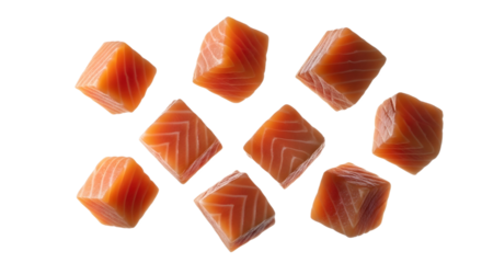 Cubed salmon pieces scattered on transparent background