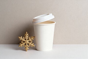 A white contact lens case with slightly ajar lid positioned next to a delicate gold snowflake against a neutral background with soft studio lighting and minimalist aesthetic, for optical retail promot