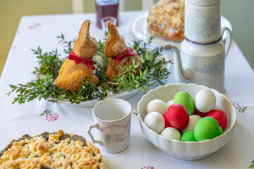 Easter holiday table setting with bunny bread and colored eggs