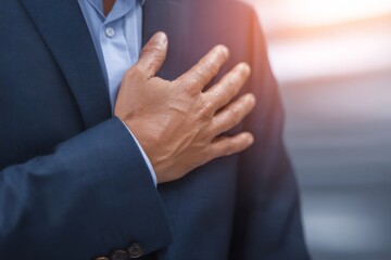 Obraz premium Businessman placing one hand over his chest, showing reassurance and confidence in communication.