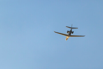 Private jet flying high in clear blue sky