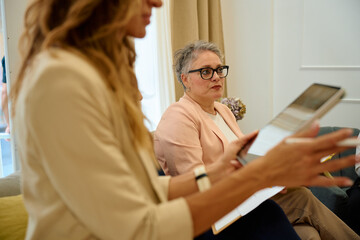 Business women discussing project using digital tablet