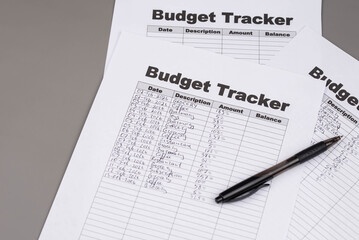 Obraz premium Open daily planner notebook on desk, with neatly handwritten organized Monthly Budget tracking table. With dates, categories and expenses. Personal finance management, spending and budgeting habits 