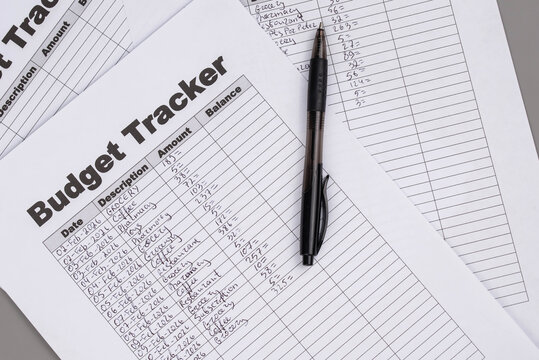 Open daily planner notebook on desk, with neatly handwritten organized Monthly Budget tracking table. With dates, categories and expenses. Personal finance management, spending and budgeting habits 